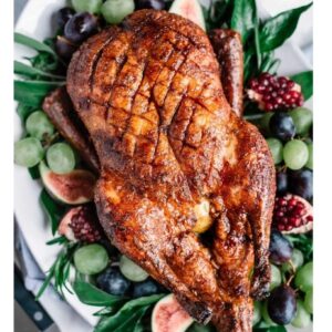 Roast Chicken baked with Chook rub sits on a bed of salad and fresh figs.